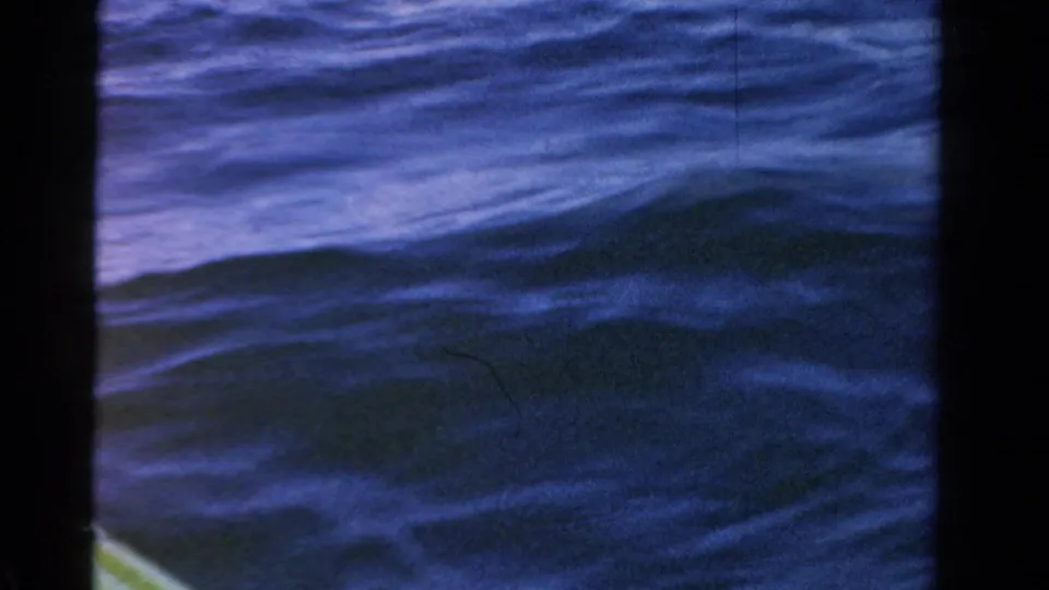 Rippled open water dominates the frame, with only a small part of the boat visible at the lower edge.