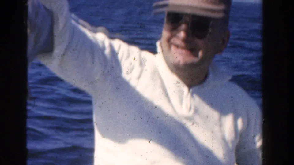 A smiling adult man in a cap and sunglasses faces the camera during a 1958 Ontario fishing outing.