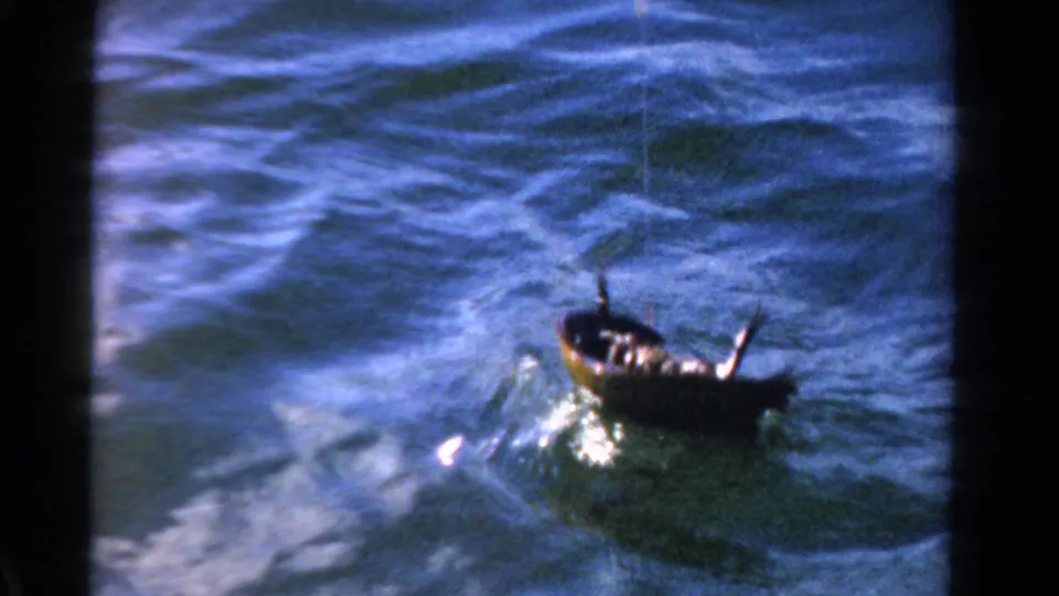 A small dark catch or boat-like object is seen on rippled blue water, apparently attached to a line in the 1958 Ontario clip.