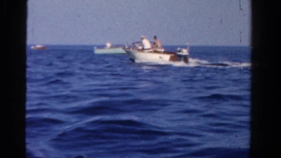 A small motorboat with passengers crosses the water in the Ontario boating footage, with another boat visible nearby.