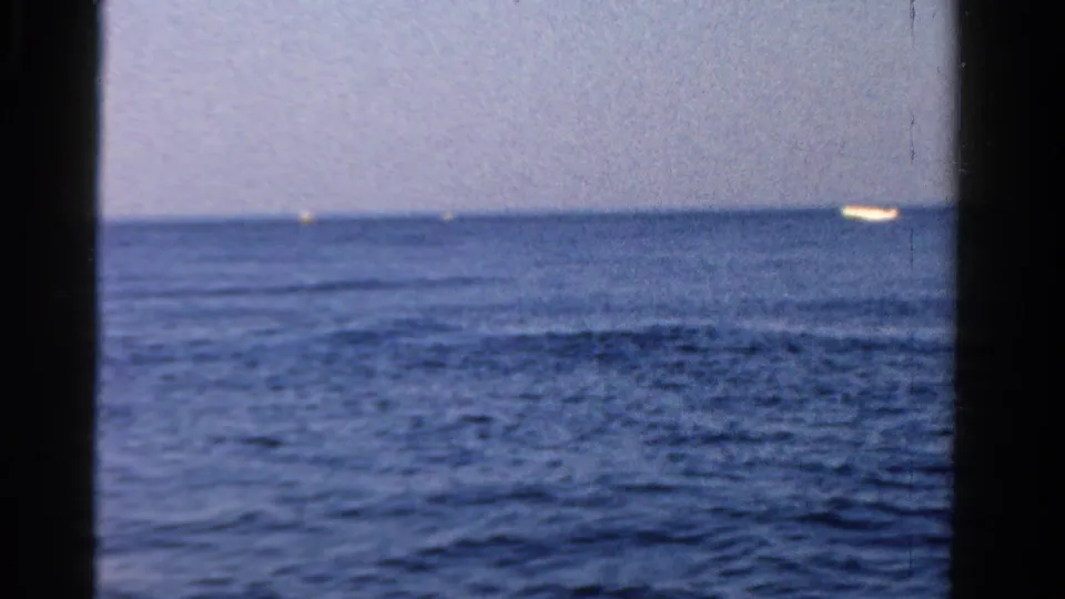 Open Ontario lake view from 1958 with a bright distant boat near the right horizon and rippled blue water.
