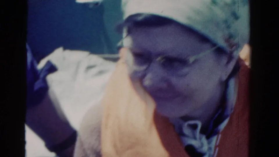Woman wearing glasses and a headscarf sits close to the camera on the boat, matching the supplied 1958 Ontario travel metadata.