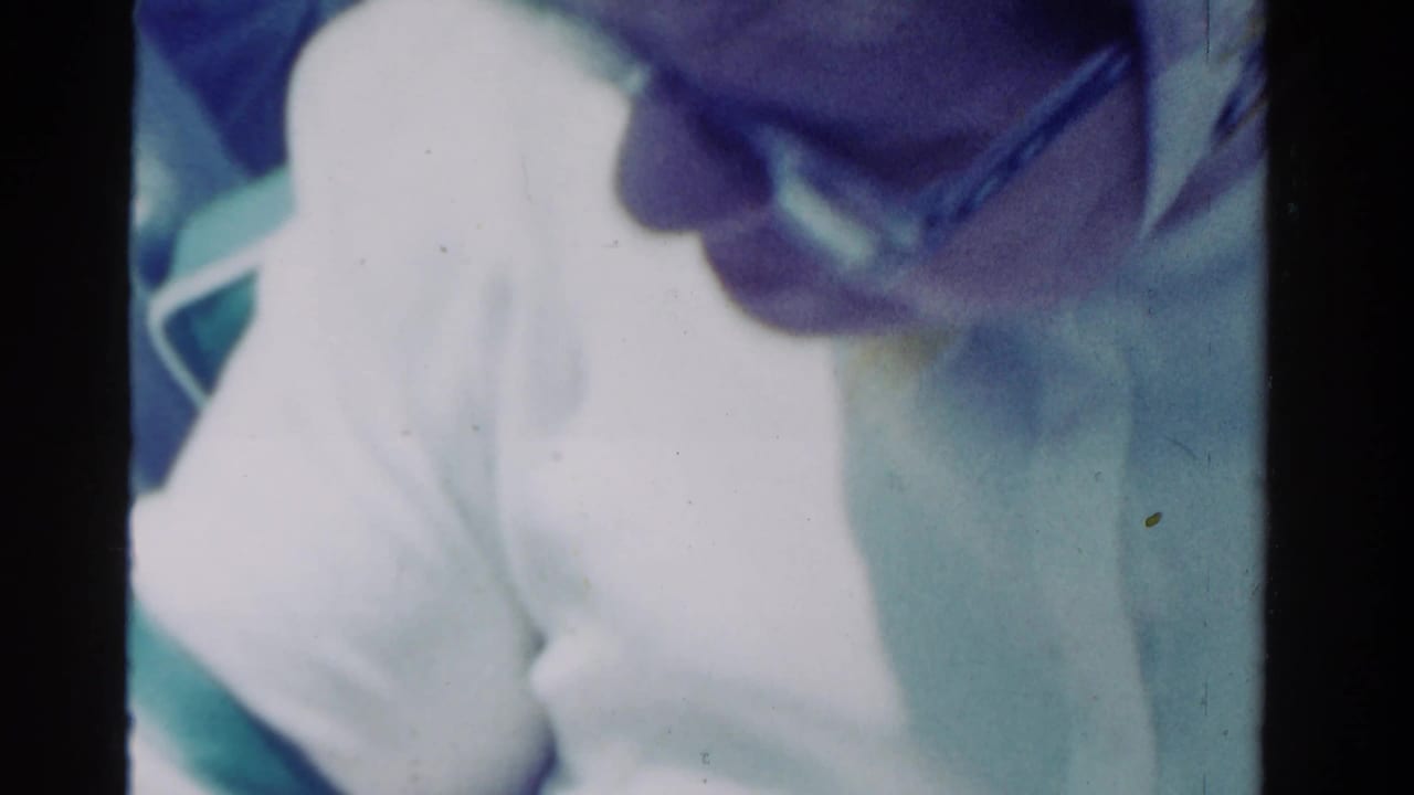 Partial close-up of a person in a white hat and another adult wearing sunglasses.