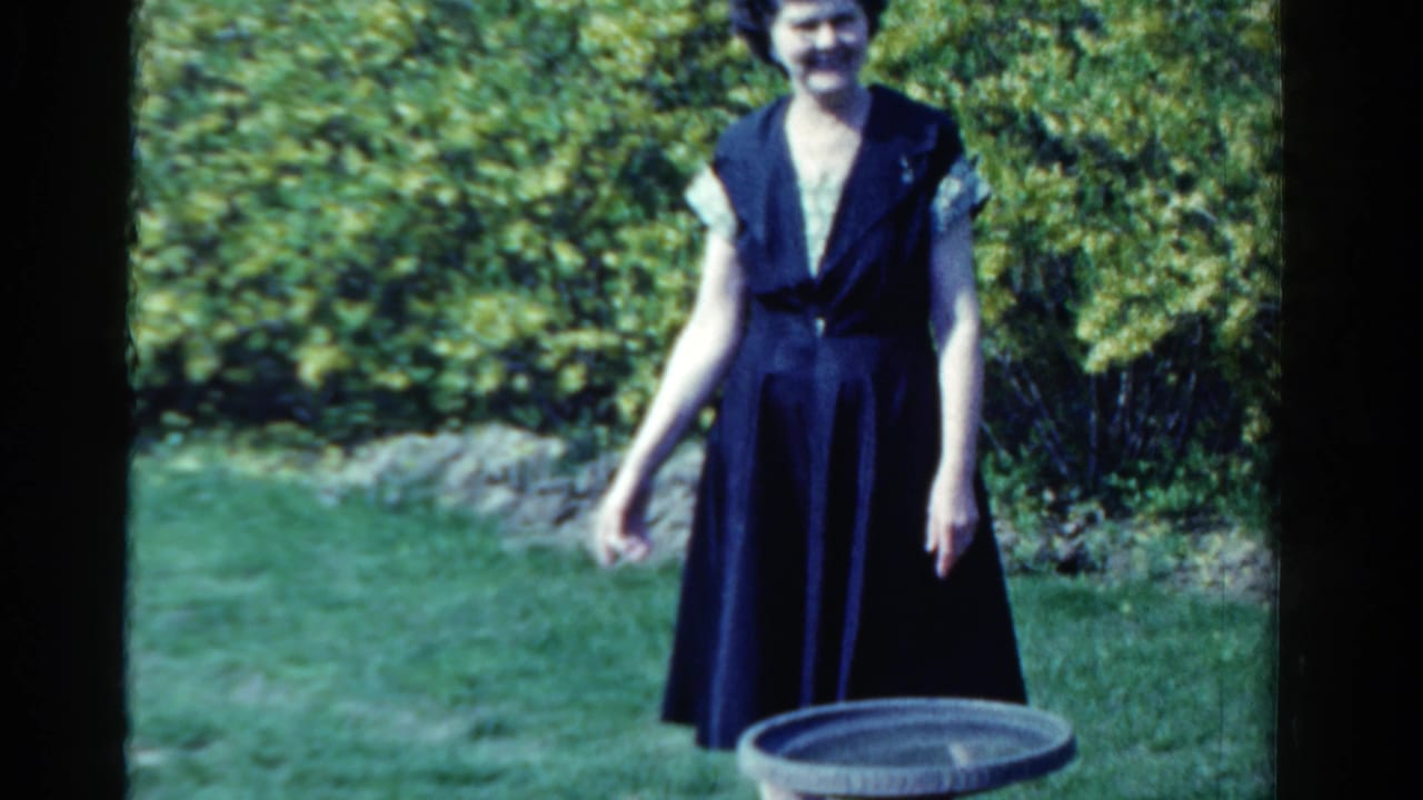 The woman stands facing the camera in an Ontario garden, with a birdbath partly visible in the foreground.