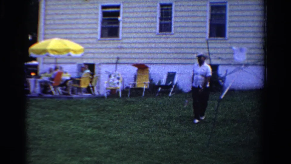 A 1958 Ontario backyard scene shows an adult holding a racket, with guests seated under a bright yellow patio umbrella.