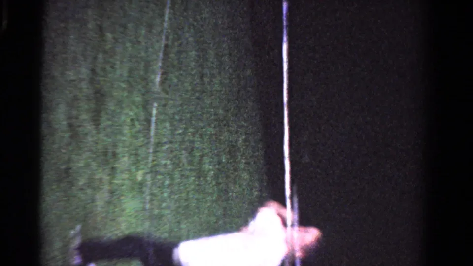 A second player in a white shirt and dark pants appears near a post on the grass court in the Ontario tennis footage.