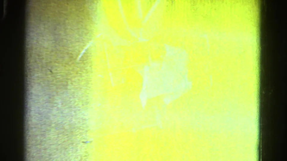 Brightly flared 8mm frame from the Ontario 1958 clip, with grass and outdoor forms mostly washed by exposure.