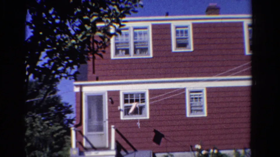 1958 Ontario frame with the house exterior cropped closer, showing siding, windows, screened door, steps, trees, and clothesline.