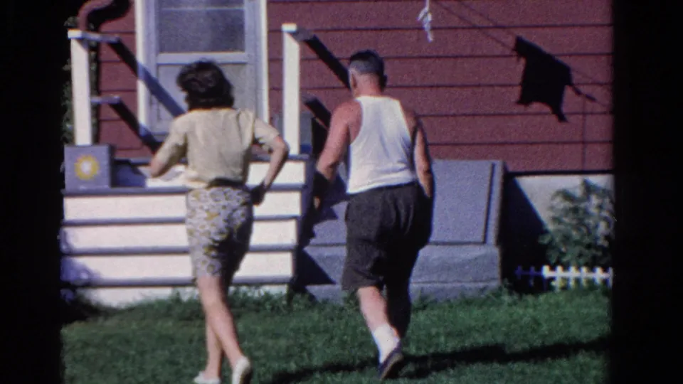 The adults continue walking toward the front entrance of the Ontario house, partly turned away from the camera in bright sun.
