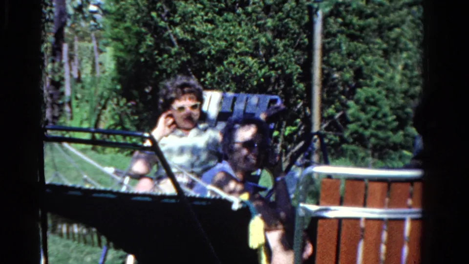 1958 Ontario backyard pool scene with a woman in sunglasses near the pool and other adults gathered in bright summer light.