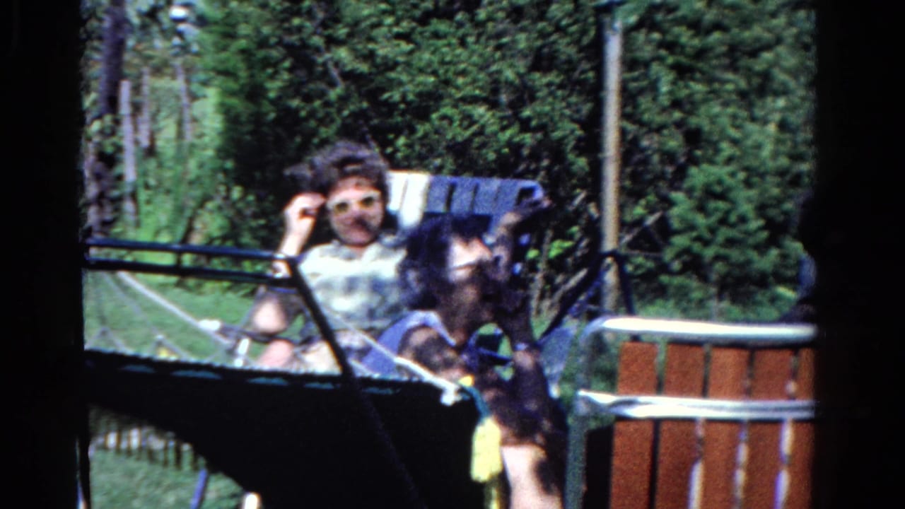 A wooded Ontario campsite scene shows adults seated in lawn chairs, with one person partly turned toward the camera.