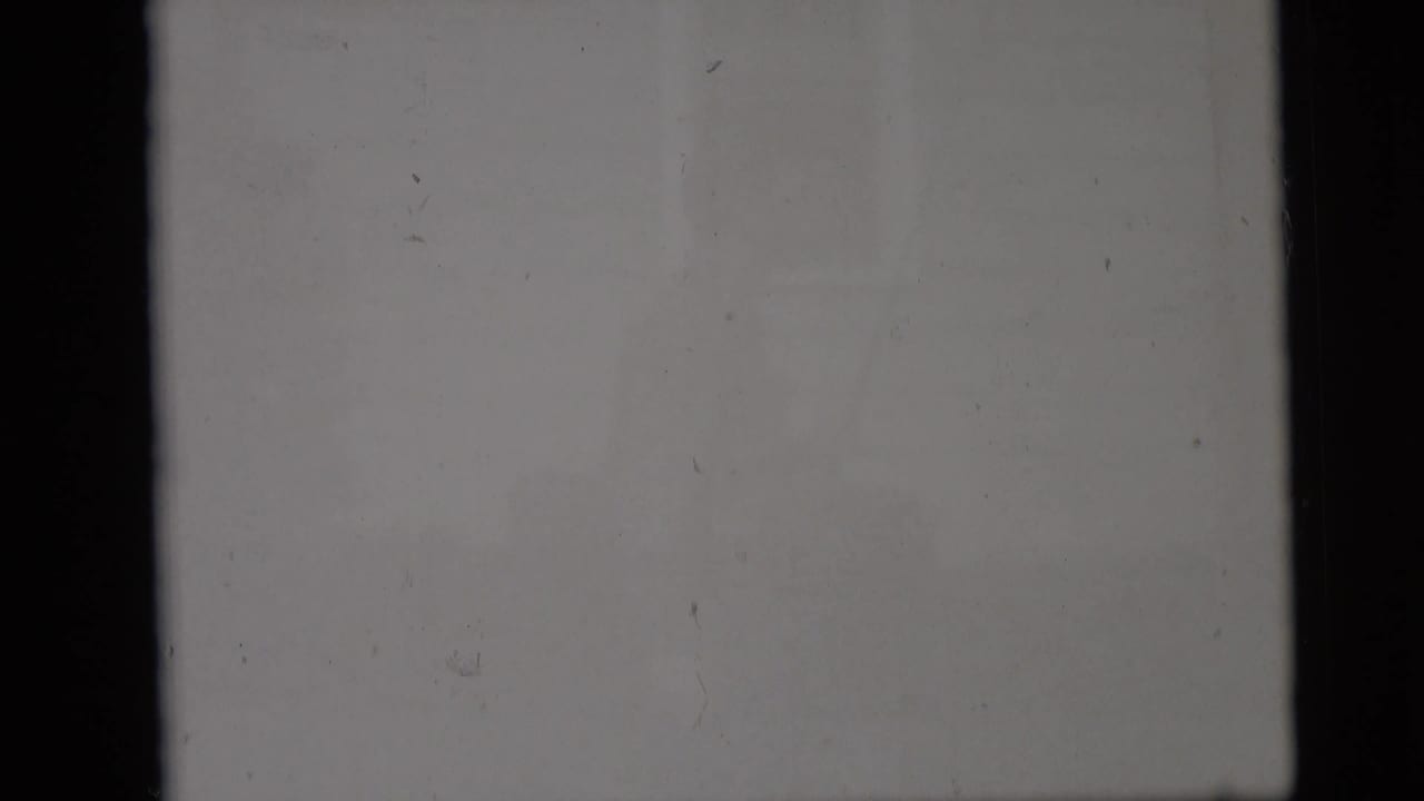 The final contact-sheet cell is largely blank or overexposed gray film, with dust specks and dark frame edges visible.