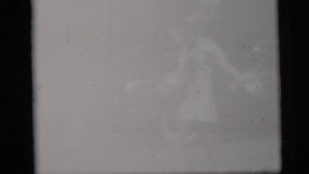 The final frame is mostly washed out, with a faint, indistinct figure visible through the overexposed 8mm image.
