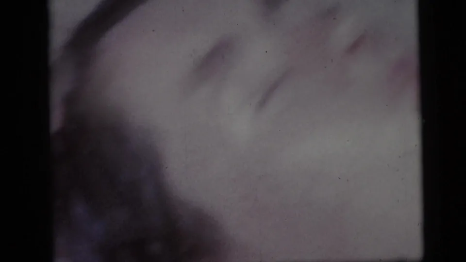 Faded 1959 Camden beach close-up showing the sleeping girl’s face in soft focus, with dark hair along the lower frame.