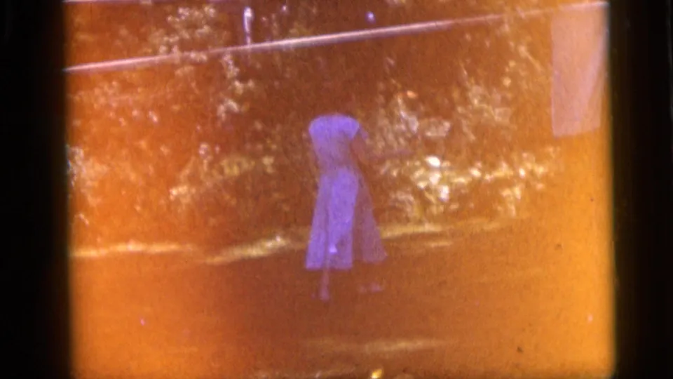 At the end of the Camden yard shot, the woman appears farther away as orange film flare washes over the trees and grass.