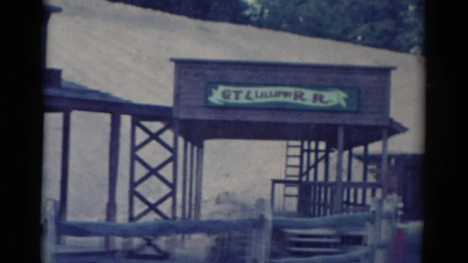 1959 Catskill frame showing the GT Lilliput R.R. sign over a themed wooden entrance with porch rails, lattice bracing, and hillside beyond.