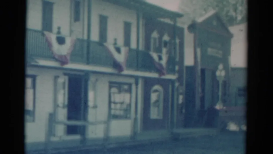 Catskill, New York 1959 frame showing the saloon facade extending toward a darker adjacent structure with visible balcony bunting.