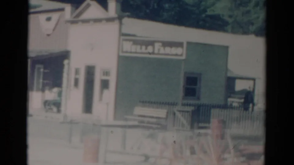 1959 Catskill frame showing the Wells Fargo storefront, bench, railing, and a partial carriage-style wheel at the lower edge.