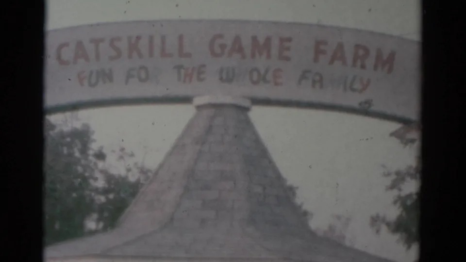 The Catskill Game Farm entrance sign reading Fun For The Whole Family spans above a pointed-roof structure in this 1959 Catskill, New York frame.