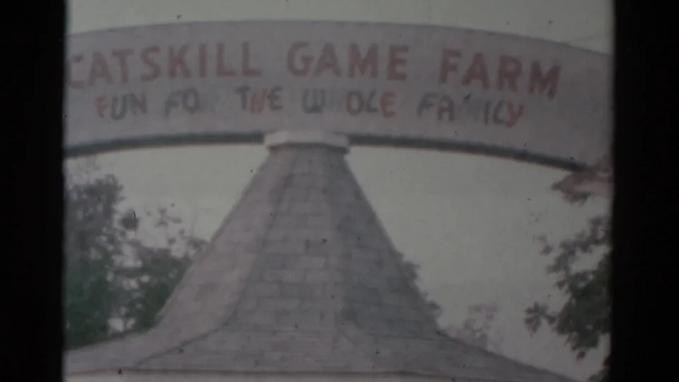 A second 8mm frame holds on the Catskill Game Farm sign and pointed-roof entrance structure, with soft color, grain, and dark frame borders.
