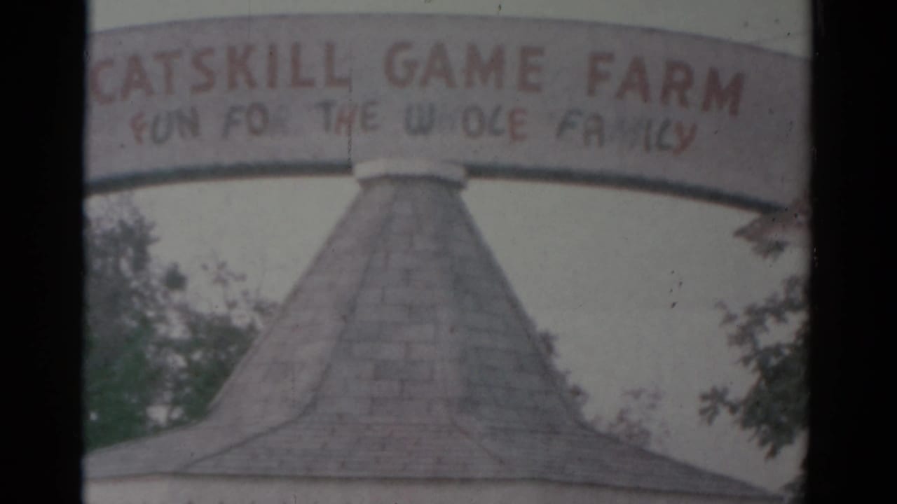 1959 home-movie frame showing the Catskill Game Farm sign above a small entrance booth in Catskill, New York.