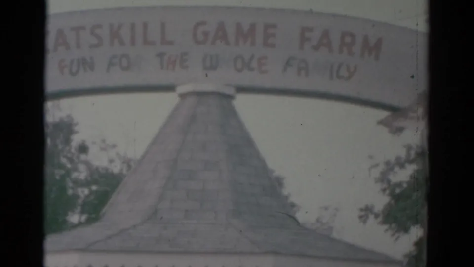 Catskill Game Farm entrance sign and conical booth roof appear in a faded 1959 8mm home-movie frame.