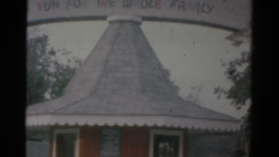 The camera tilts lower on the Catskill Game Farm entrance, showing the booth roof, scalloped trim, and partial sign.