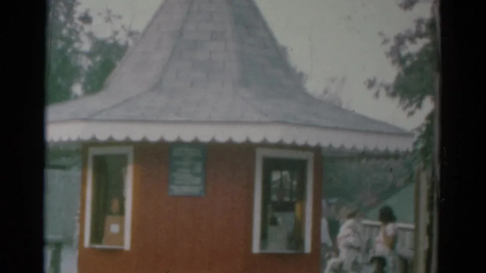 1959 Catskill Game Farm entrance booth with posted sign, windows, scalloped trim, and visitors approaching on the right.