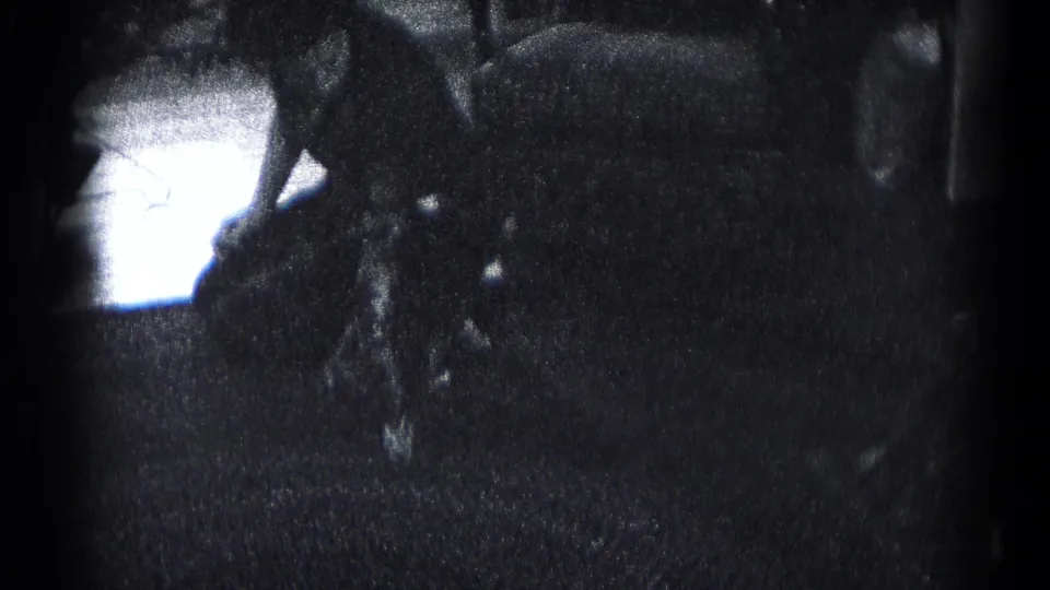 The home-movie frame shows a person low to the floor near furniture and a table edge in a private Hagerstown interior.