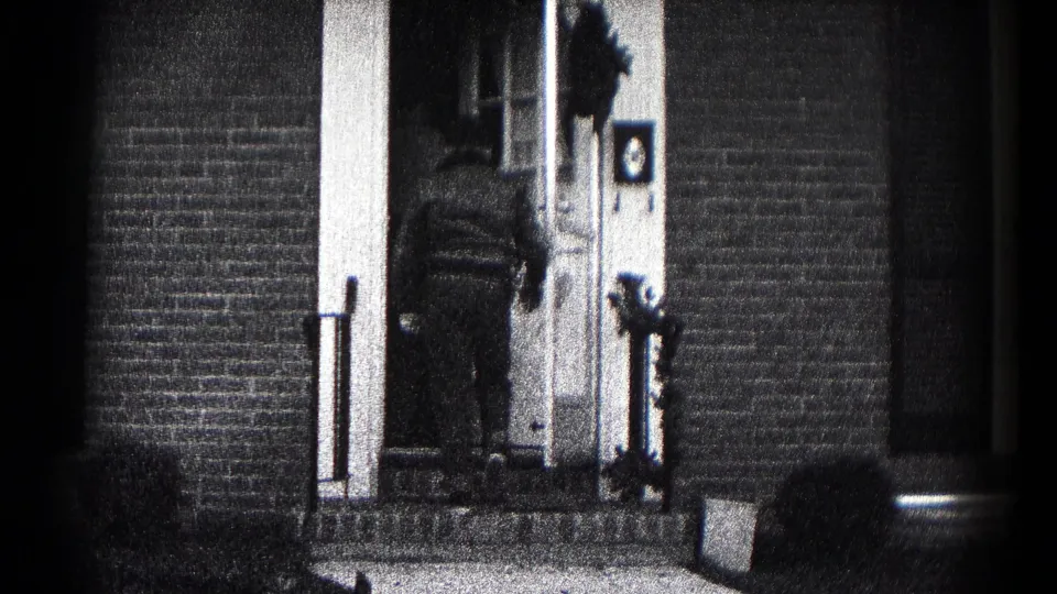 At the end of the 1959 Hagerstown clip, a man stands by the front door of the brick house as the action moves inside.