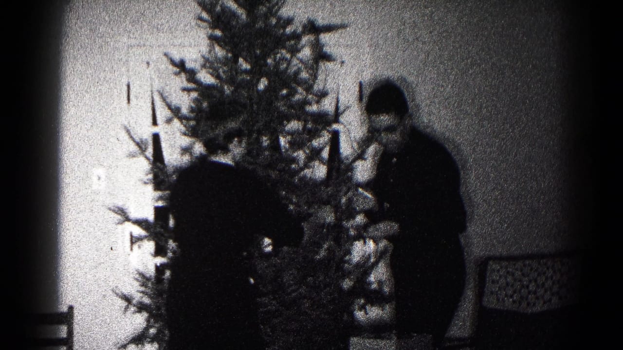 Adults decorate a Christmas tree in a black-and-white living room scene.