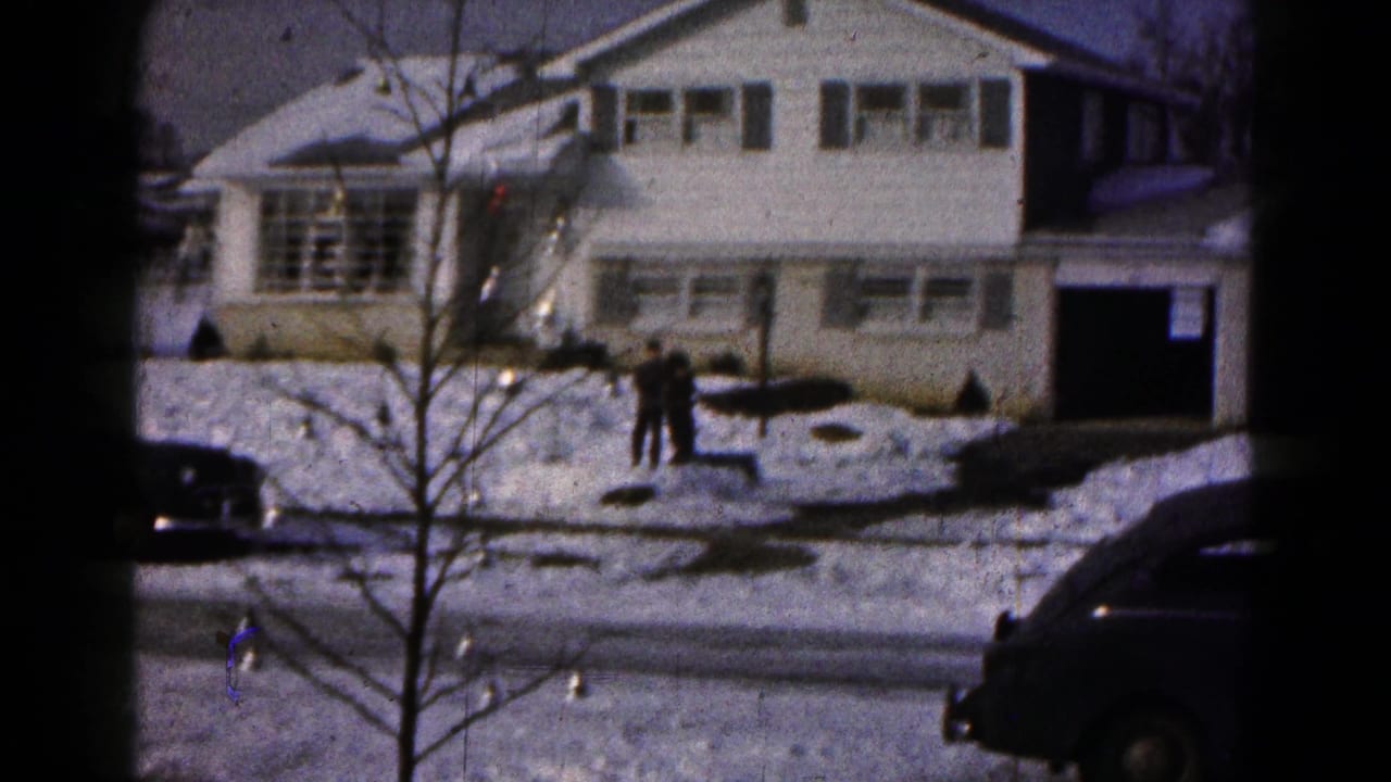 Winter exterior of a snow-covered suburban house in Hagerstown, Maryland, with people near the front walk and dark cars by the street.