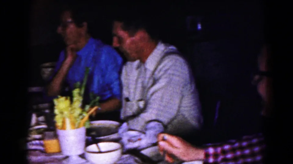 1959 Hagerstown frame showing men at a family meal table with dishes, glasses, and celery in the foreground.