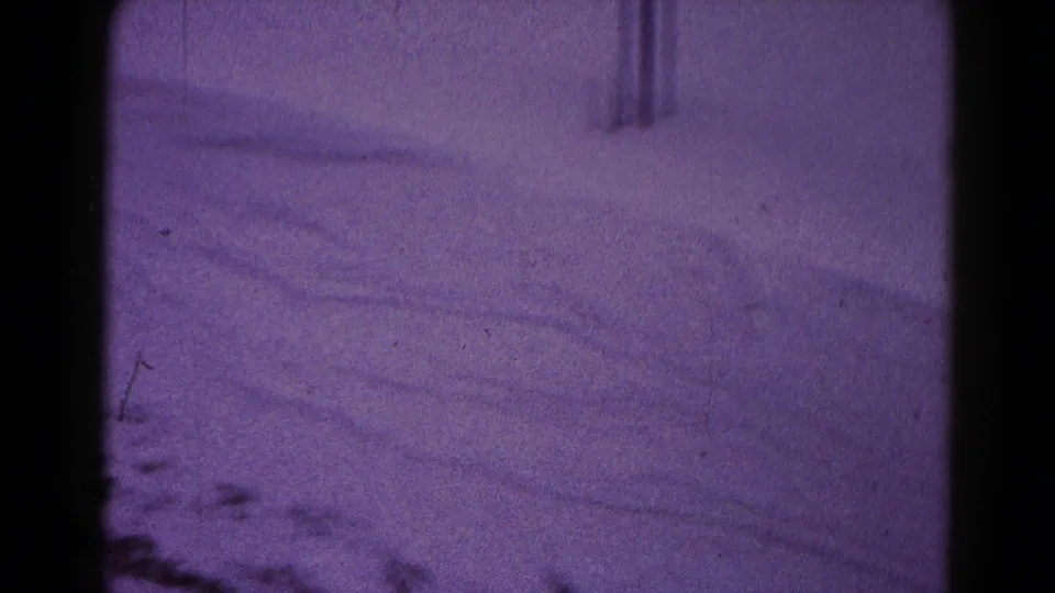 Purple-tinted 1959 Hagerstown winter frame showing a snowy yard, faint structural shapes, and 8mm film grain.