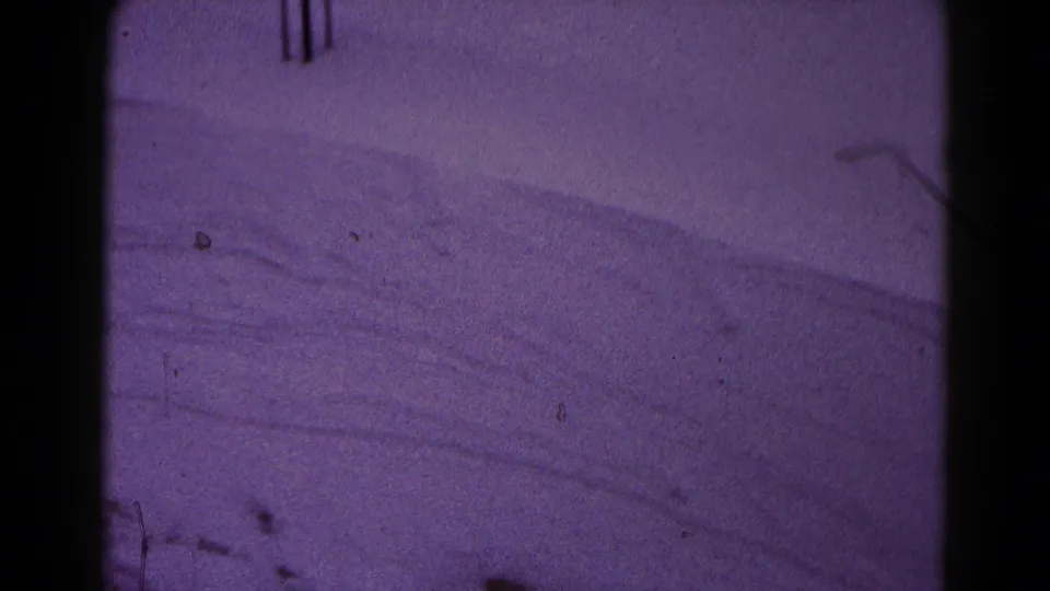 8mm home-movie frame from Hagerstown showing smooth snowdrifts, subdued exposure, and visible film dust.