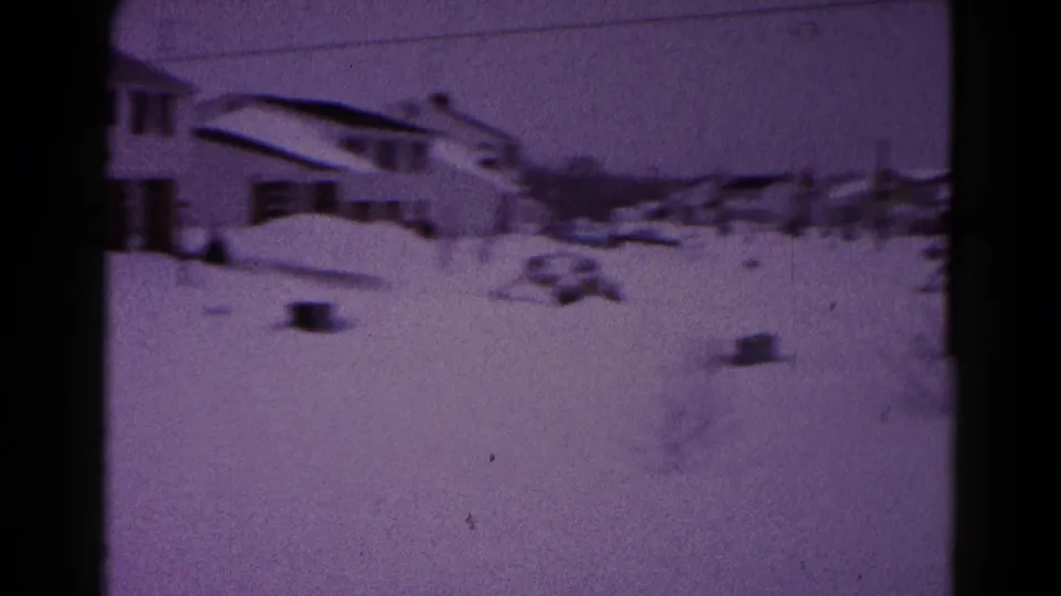 Residential Hagerstown snowstorm scene with houses, overhead wires, deep snow, and a partially buried car in the distance.