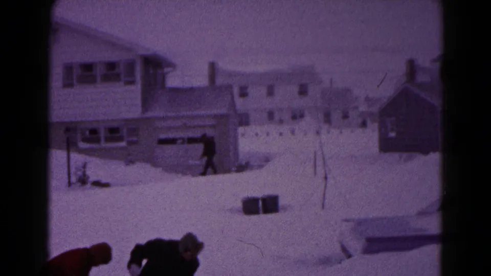 The frame looks across a snow-covered Hagerstown residential area, with shovelers low in frame and another person walking near a house.