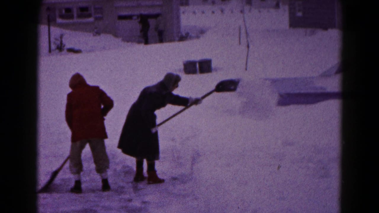 In Hagerstown, Maryland, two men in heavy coats clear snow from a residential area in 1959 home-movie footage.