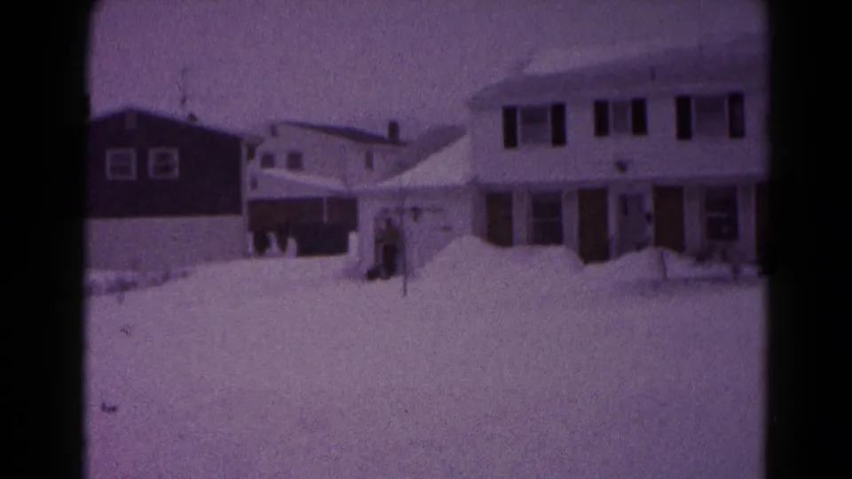 1959 Hagerstown home-movie view of snow-covered suburban houses and deep winter accumulation across front yards.