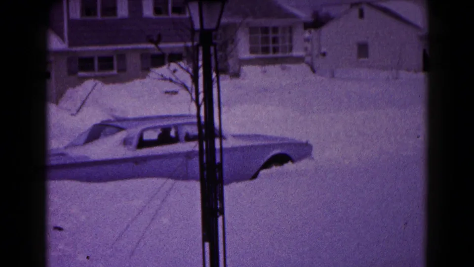 The final snowy exterior frame shows the classic sedan partly exposed in deep snow, with Hagerstown houses and bare branches behind it.