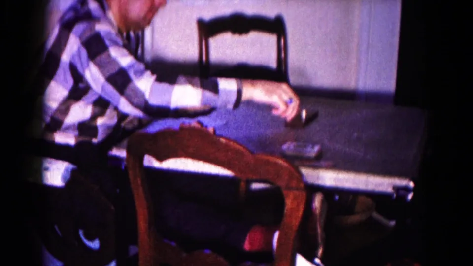 A man in a blue checkered shirt leans toward the card table in this 1959 Hagerstown living-room scene.