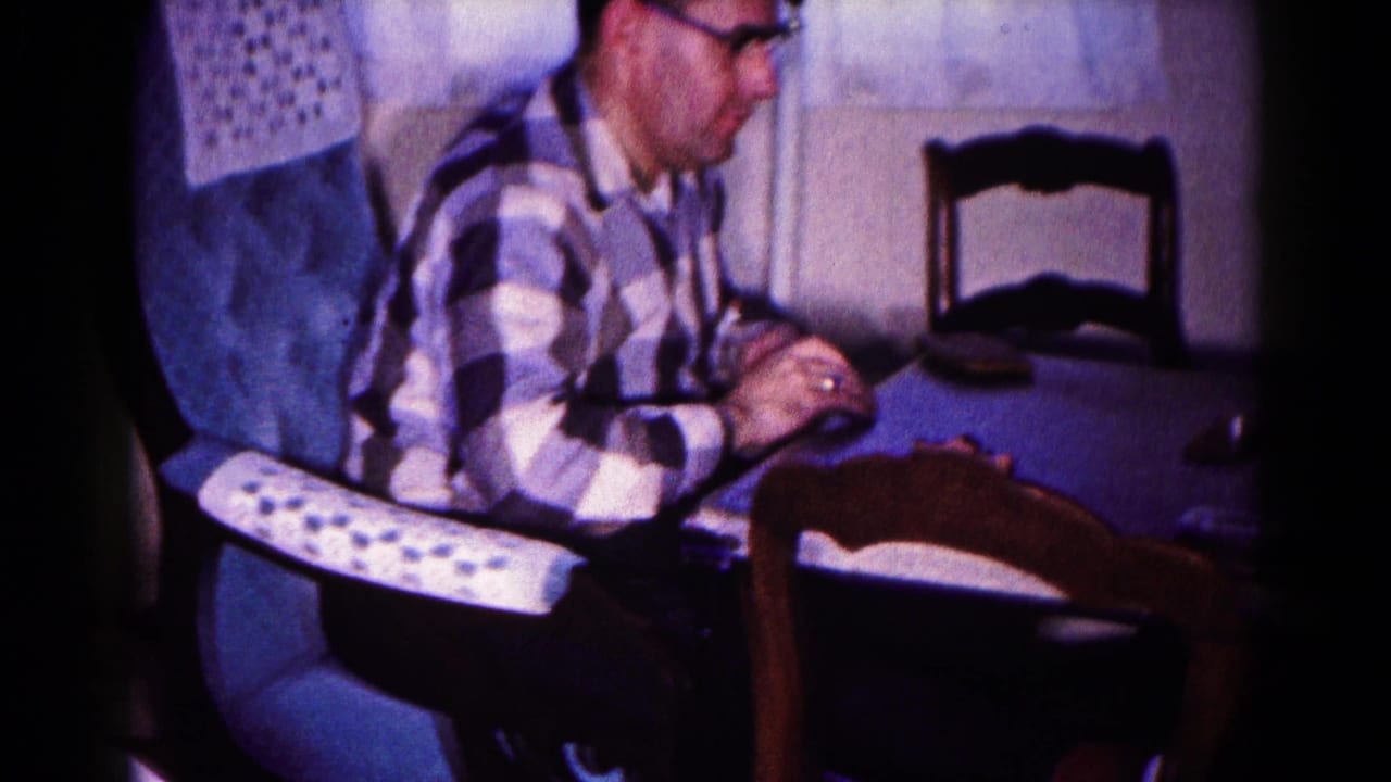 A man in glasses continues the card game at a household table in 1959 Hagerstown, Maryland footage.