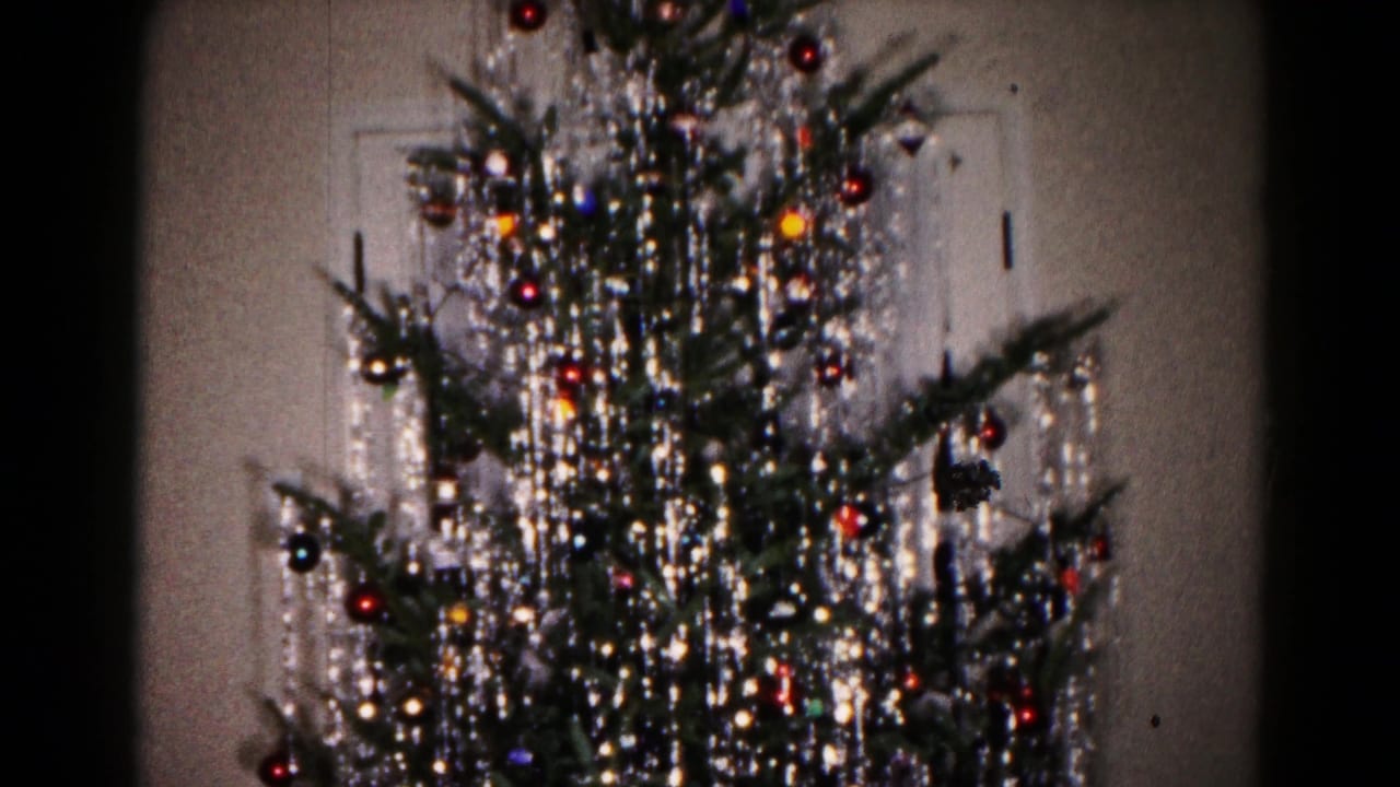 1959 Hagerstown home-movie frame showing a decorated Christmas tree with silver tinsel, colored ornaments and small lights indoors.
