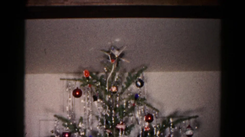 1959 Hagerstown home-movie frame showing the top of the Christmas tree with a star topper, ornaments, and tinsel.