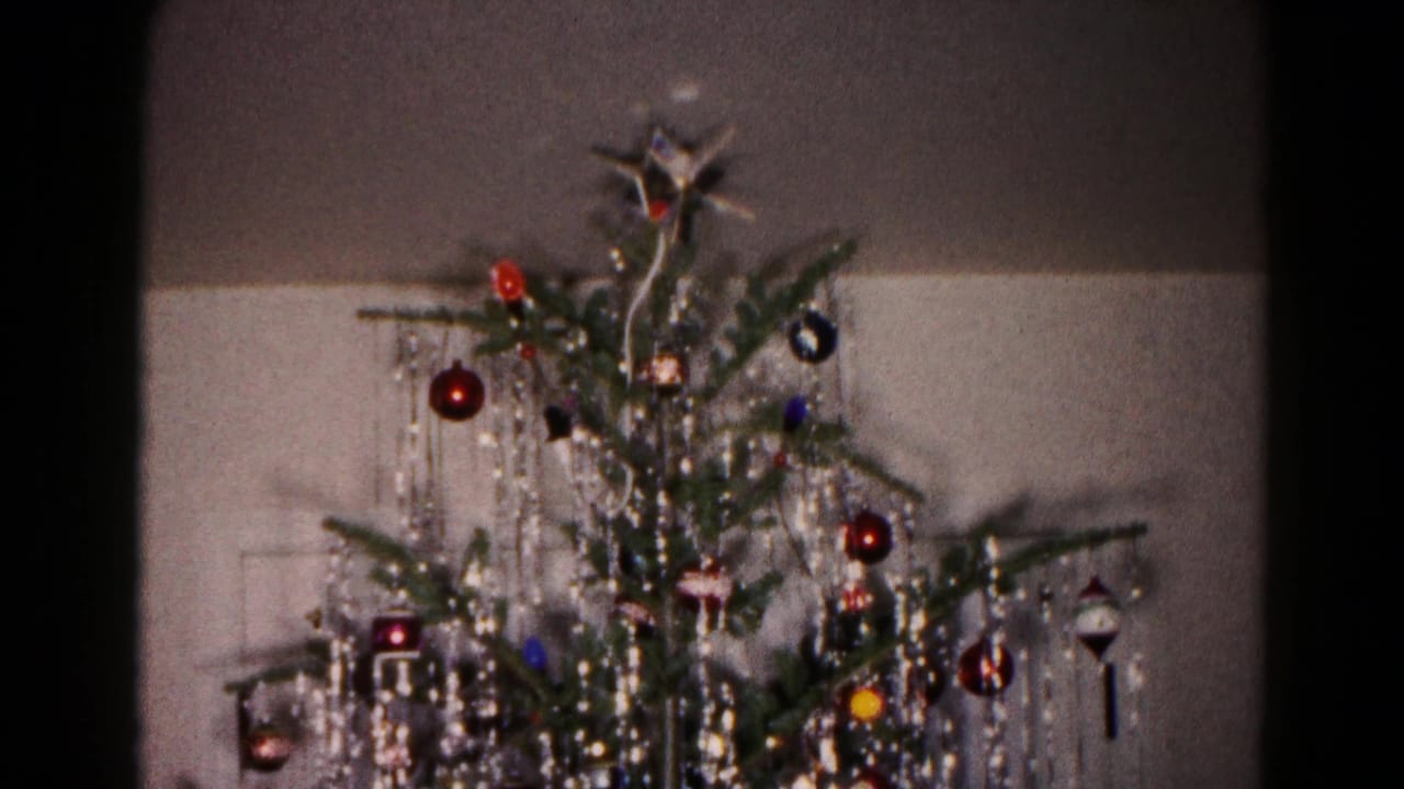 Christmas tree upper section with shiny ornaments and hanging silver tinsel.