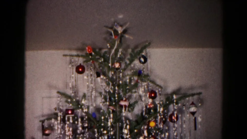 1959 Hagerstown home-movie frame of a Christmas tree decorated with glass ornaments, silver tinsel, and a star near the top.