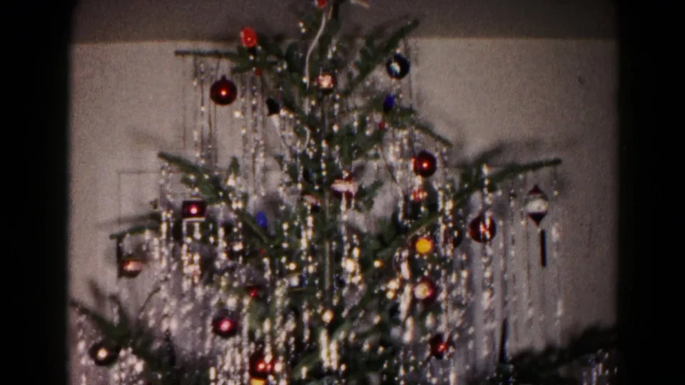 1959 Hagerstown 8mm frame showing a close view of a decorated Christmas tree with dense silver tinsel and colored ornaments.