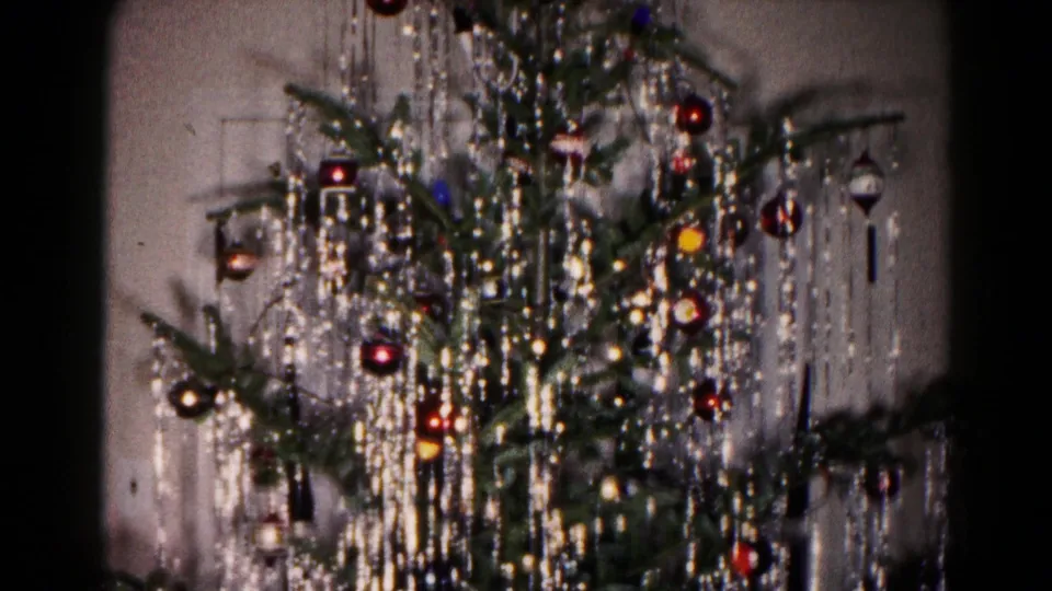 1959 Hagerstown home-movie frame showing the decorated Christmas tree with ornaments, tinsel, and soft indoor shadows.