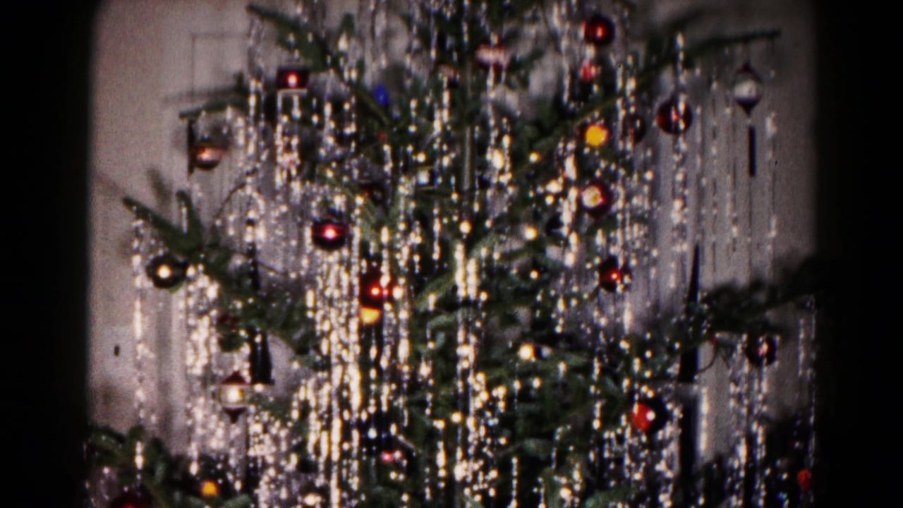 1959 Hagerstown home-movie frame showing a Christmas tree with heavy silver tinsel, red ornaments, and colored lights.