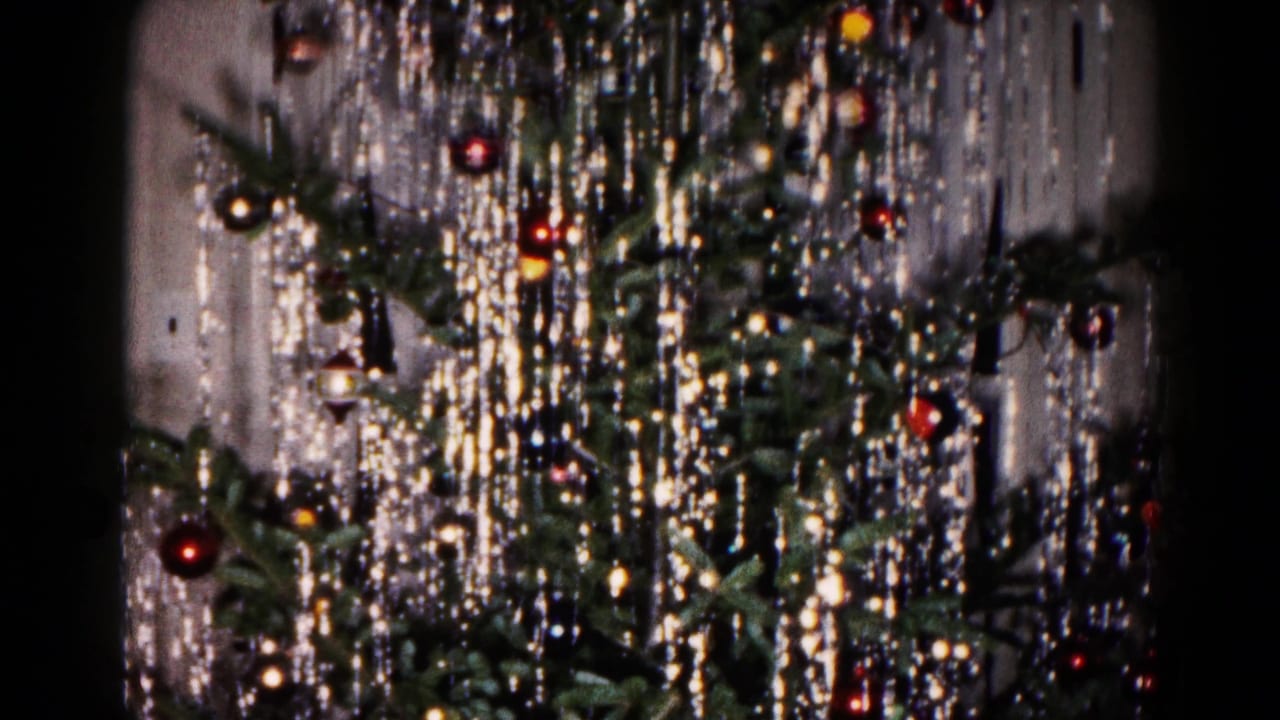 Close 8mm view of a decorated Christmas tree in Hagerstown, Maryland, with silver tinsel, red and gold baubles, and soft light reflections.